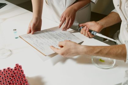 Pesquisadores colaboram em um laboratório, analisando documentos e equipamentos durante uma pesquisa científica.