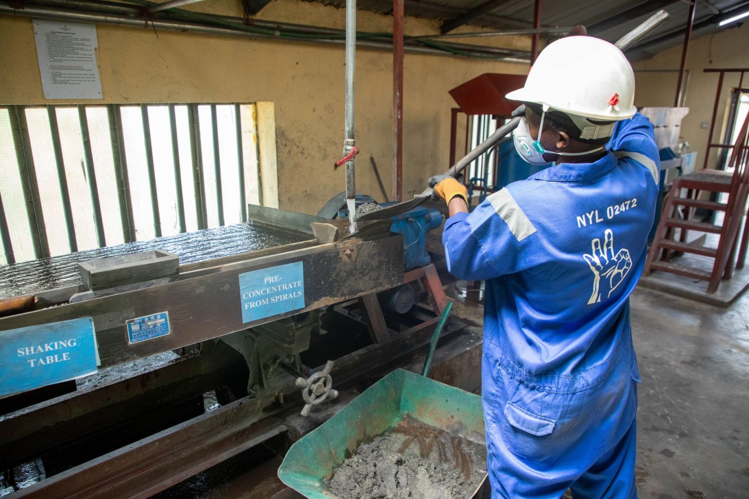 Trabalhador usando equipamento de concentração de minério em uma unidade industrial de processamento mineral.