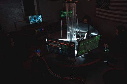 Equipe de especialistas em cibersegurança trabalhando diante de computadores em uma sala escura.