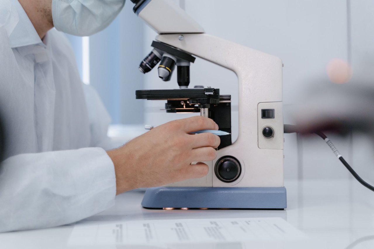 Pesquisador analisa amostras ao microscópio em um laboratório científico.
