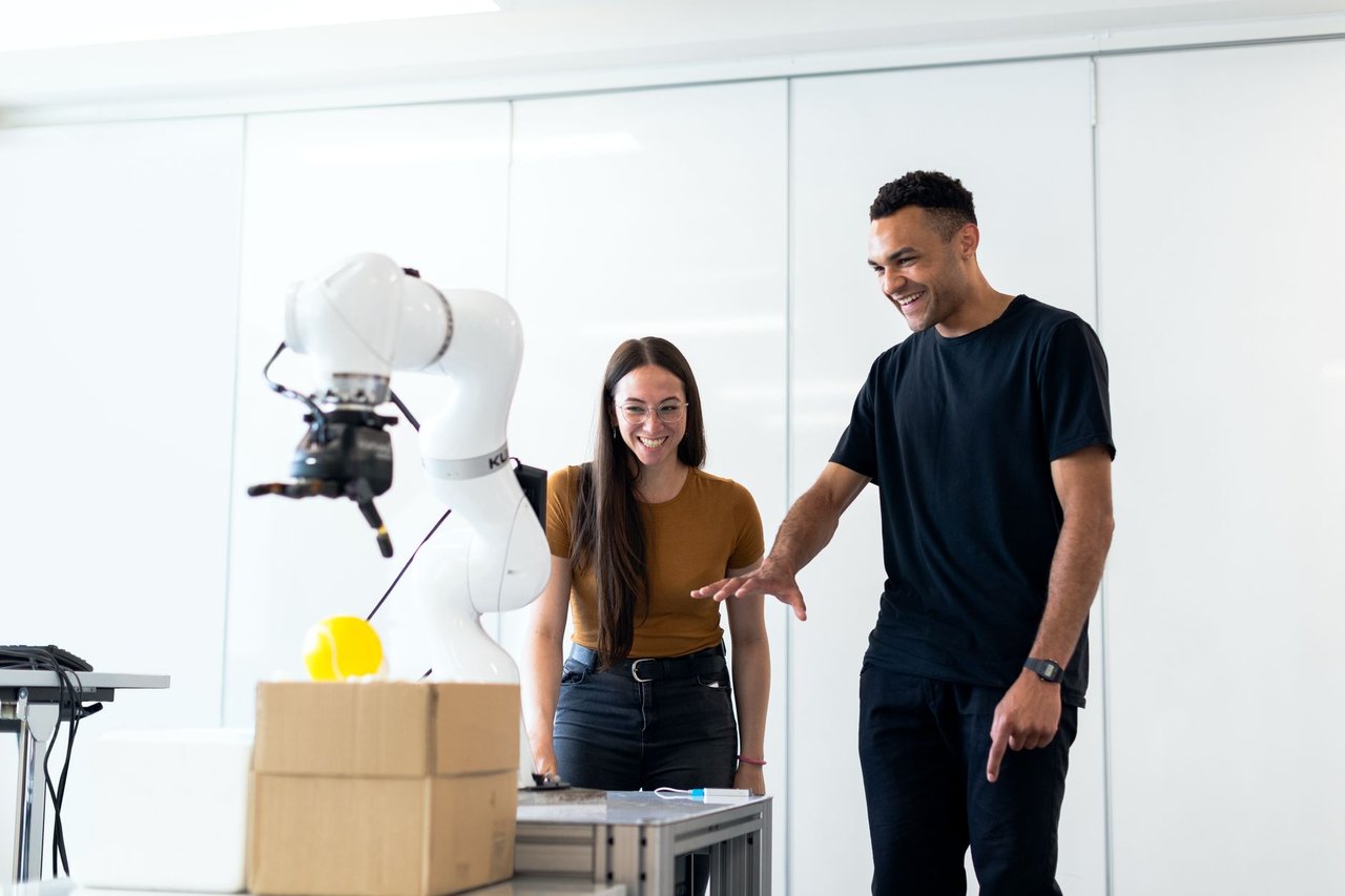 Dois engenheiros testam um protótipo robótico futurista em um laboratório.