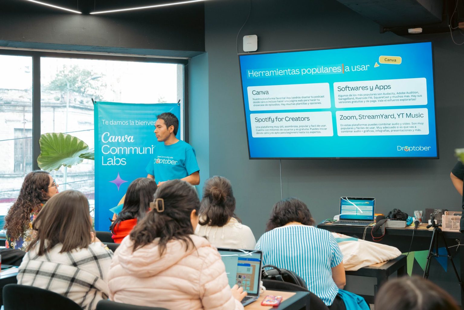 Pessoa apresenta ferramentas tecnológicas a participantes durante um workshop.