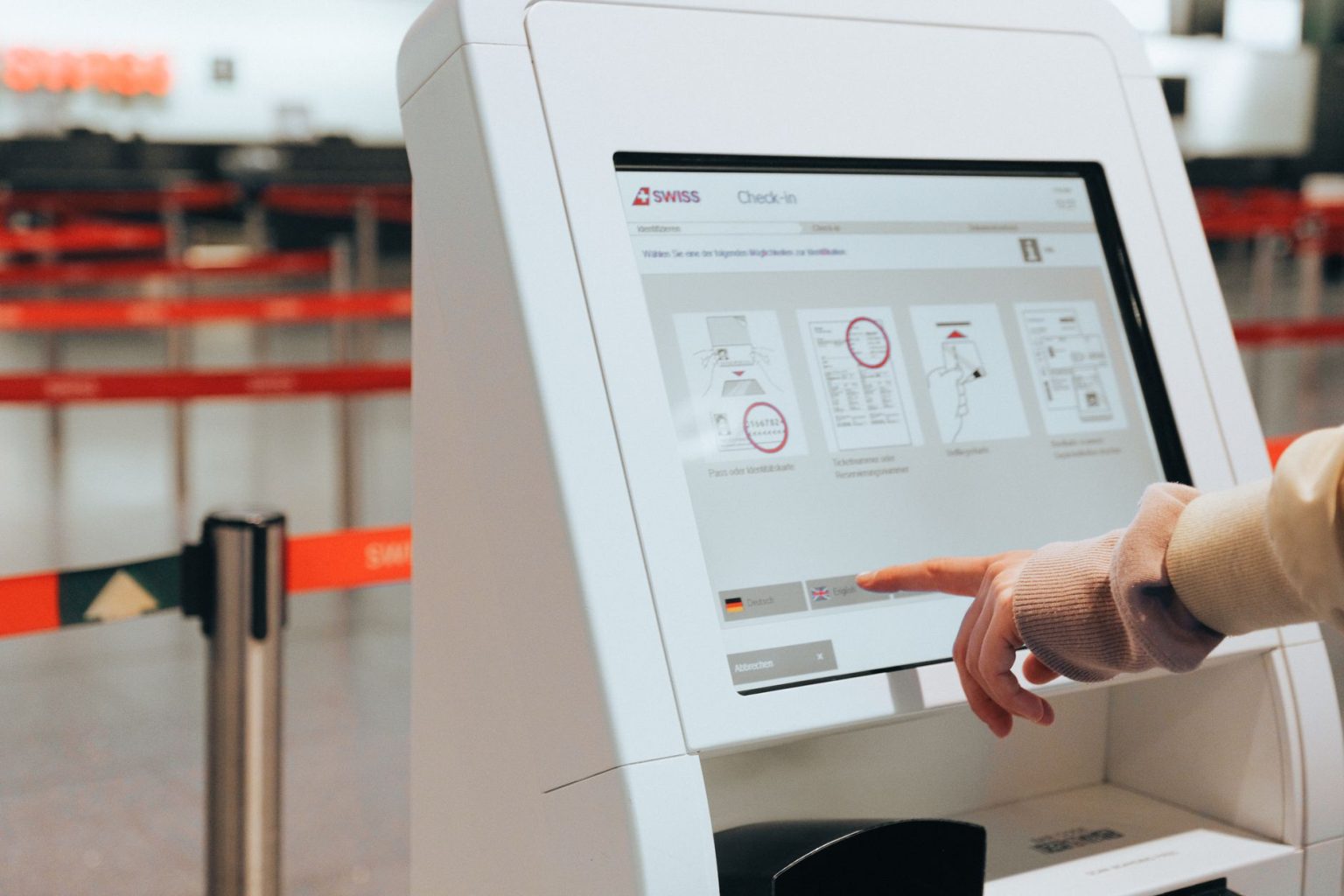 Passageira utiliza um quiosque de autoatendimento em um aeroporto.